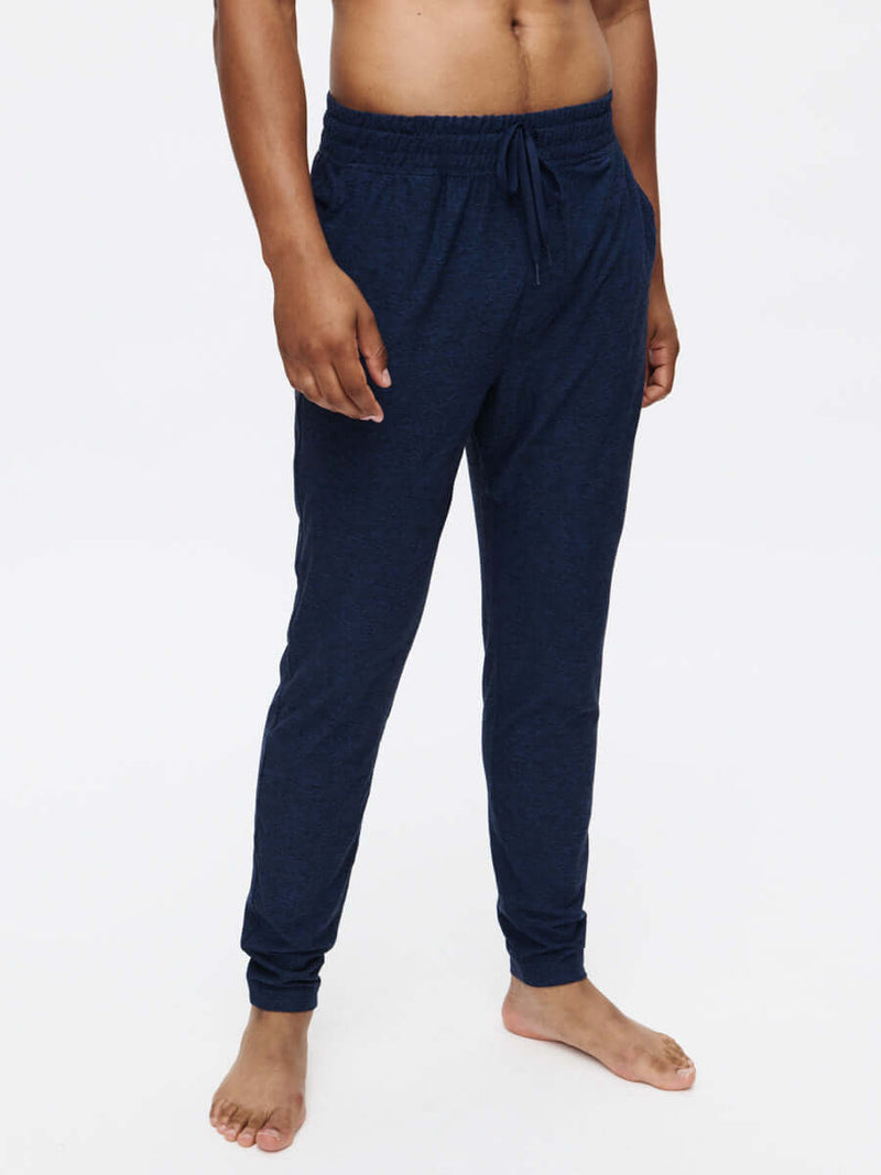 Model standing in CloudKnit Slim Sweatpant, soft navy fabric with adjustable drawstring waistband, ideal for everyday wear.