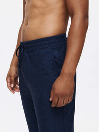 Side view of man wearing CloudKnit Slim Sweatpant in Navy, featuring a custom-fit drawstring waistband and pockets.