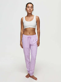 A model showcases the CloudKnit Sweatpant in light pink, paired with a white crop top, for casual comfort.