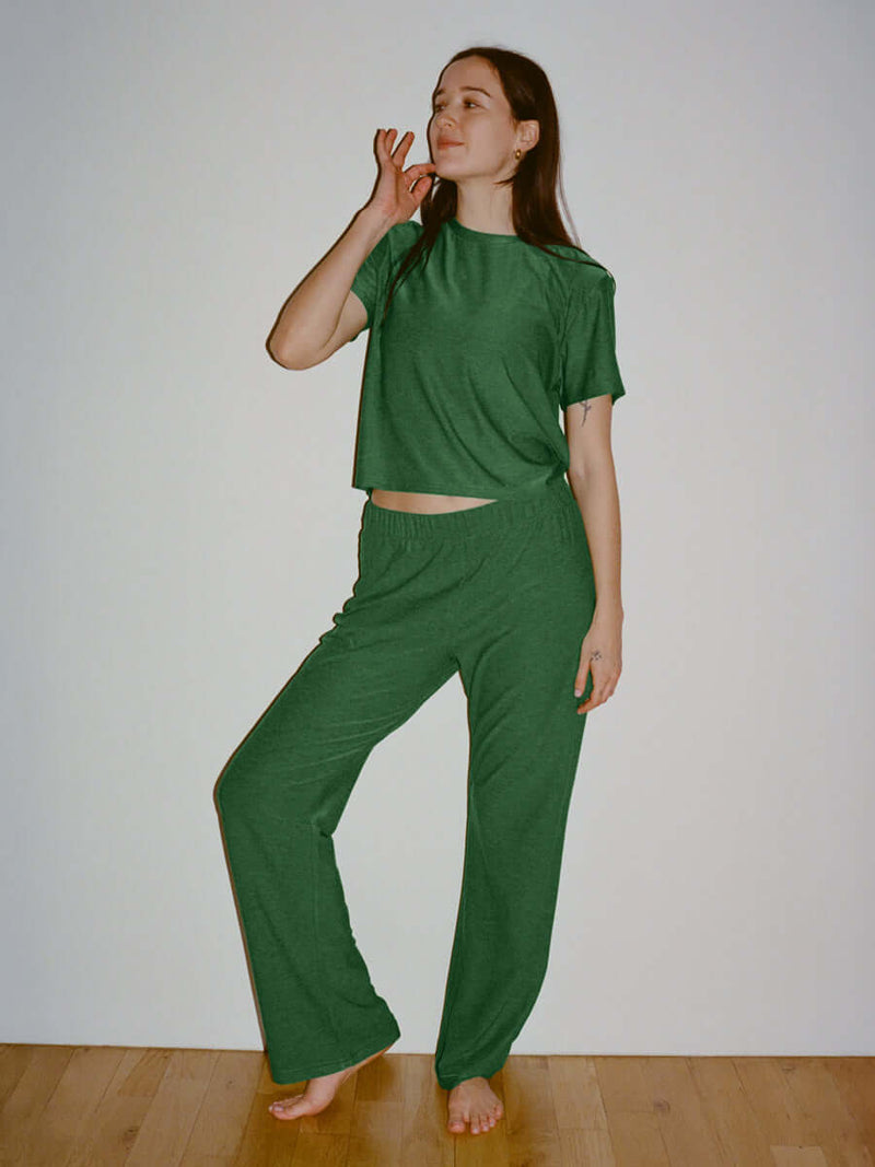 Model in green CloudKnit Wide Leg Pant and matching top, enjoying a relaxed pose with a cheerful expression.