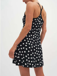 Model viewed from the back wearing Club Dress in Black with white polka dots and adjustable straps.