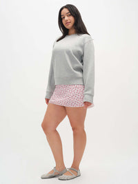 Model wearing Club Skort with a playful print, paired with a cozy grey sweatshirt for an active look.