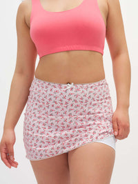 Model wearing Club Skort in white with pink floral print, featuring a cute bow at the waistband.