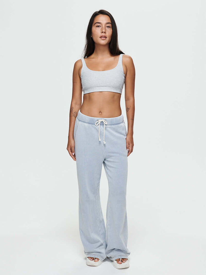 Model standing in Desert Pant in soft blue, wide-leg denim cotton terry with elastic waistband and drawcord.