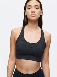 Model wearing Doing Things Bra in Black, featuring a scoop neck and snug fit for activewear.