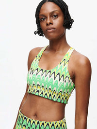 Model with the vibrant Doing Things Bra CL in green and black wavy pattern.