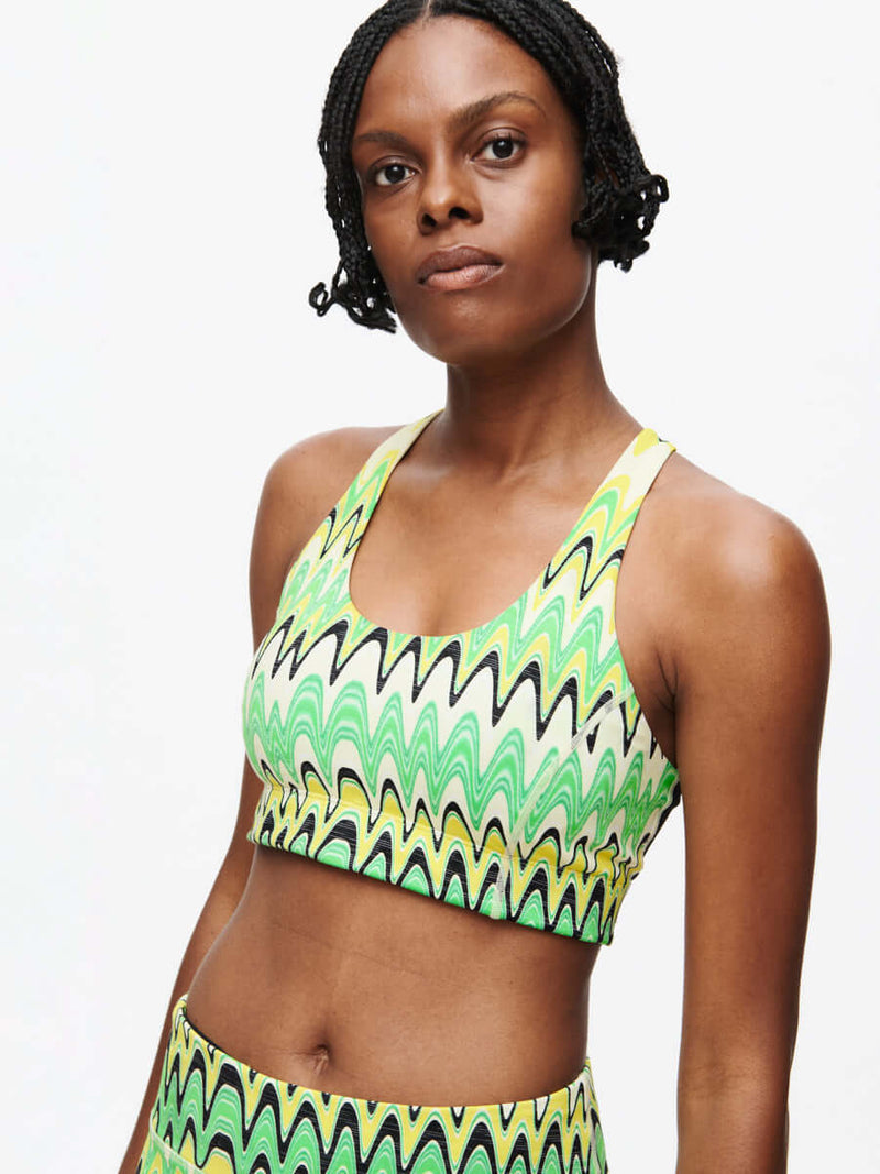 Model with the vibrant Doing Things Bra CL in green and black wavy pattern.