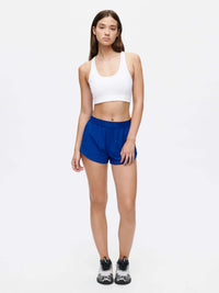 Model wearing Doing Things Bra in White with mesh backing, styled for activewear workouts.