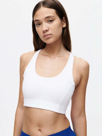 Model wearing Doing Things Bra in White with a scoop neck and supportive fit for active lifestyles.