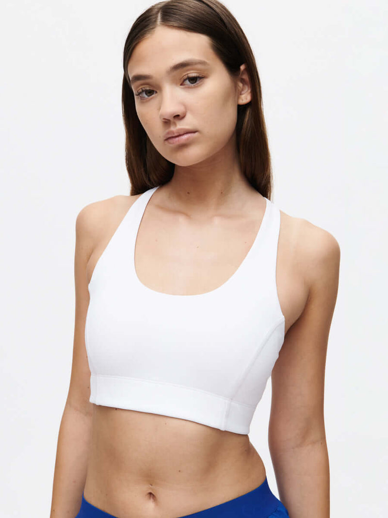 Model wearing Doing Things Bra in White with a scoop neck and supportive fit for active lifestyles.