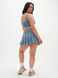 Model showing back view of Doing Things 3" Skort in blue, with pleated design and built-in shorts.