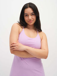 Model wearing The Exercise Dress in Lavender with adjustable straps and a built-in shorts liner, ready for movement.