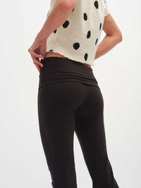 Model from behind wearing Flared Legging in Black, with the tall waistband and smooth fit.