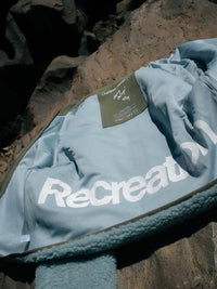 Flat lay of Candy Fleece Jacket in Soft Blue, with soft fabric and logo detail.