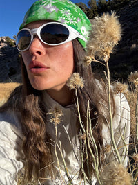 Close-up of a model wearing Frosted Beanie in green with exclusive Elf Garden print, styled with sunglasses.