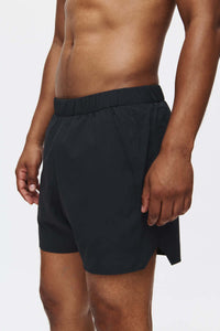 Model in profile wearing High Stride 5" Short with Pockets in Black, featuring a lightweight training design.