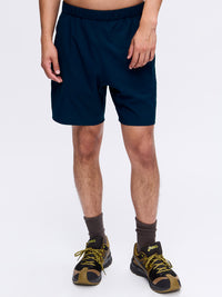 Model wearing High Stride 7" Short with Pockets in Navy, featuring a comfortable elastic waistband.
