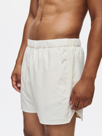 Model wearing High Stride 5" Short with Pockets in Light Cream, showing front pockets and a comfortable fit.