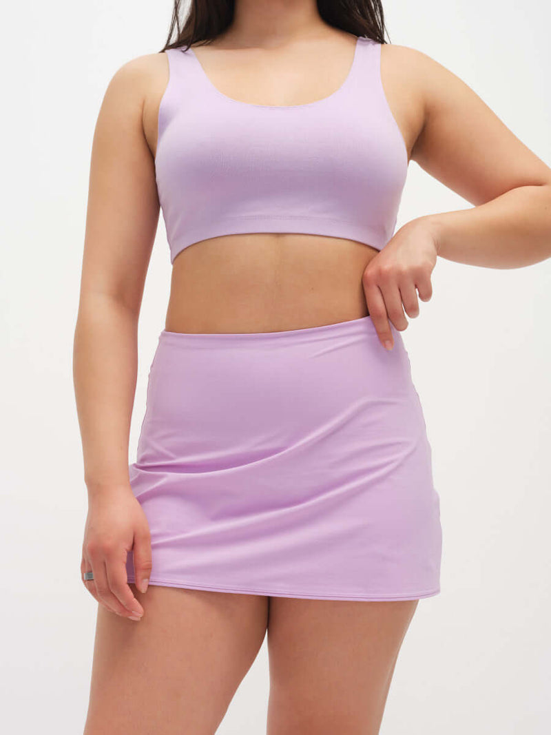 Model wearing LightSpeed Minimal 3" Skort in Lavender with a built-in shorts liner, ready for activewear.