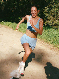 Runner in LightSpeed Minimal 3" Skort in Sky Blue, showing built-in shorts liner while jogging.
