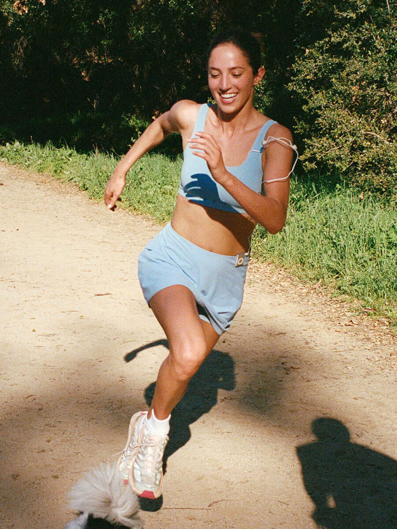 Runner in LightSpeed Minimal 3" Skort in Sky Blue, showing built-in shorts liner while jogging.