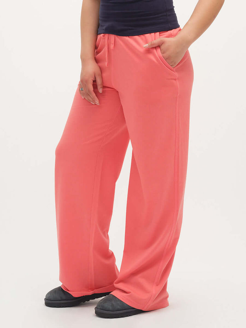 Model wearing Malibu Sweatpant in Coral, featuring wide leg design and side pockets for everyday comfort.
