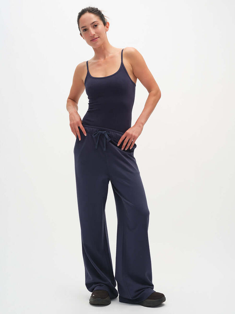 Model wearing Malibu Sweatpant in Navy, wide leg design with side pockets and elastic waistband.