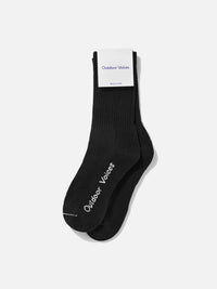 Flat lay of OV Solid Crew Sock in Black, featuring the Outdoor Voices logo on the foot and a plush knit design.