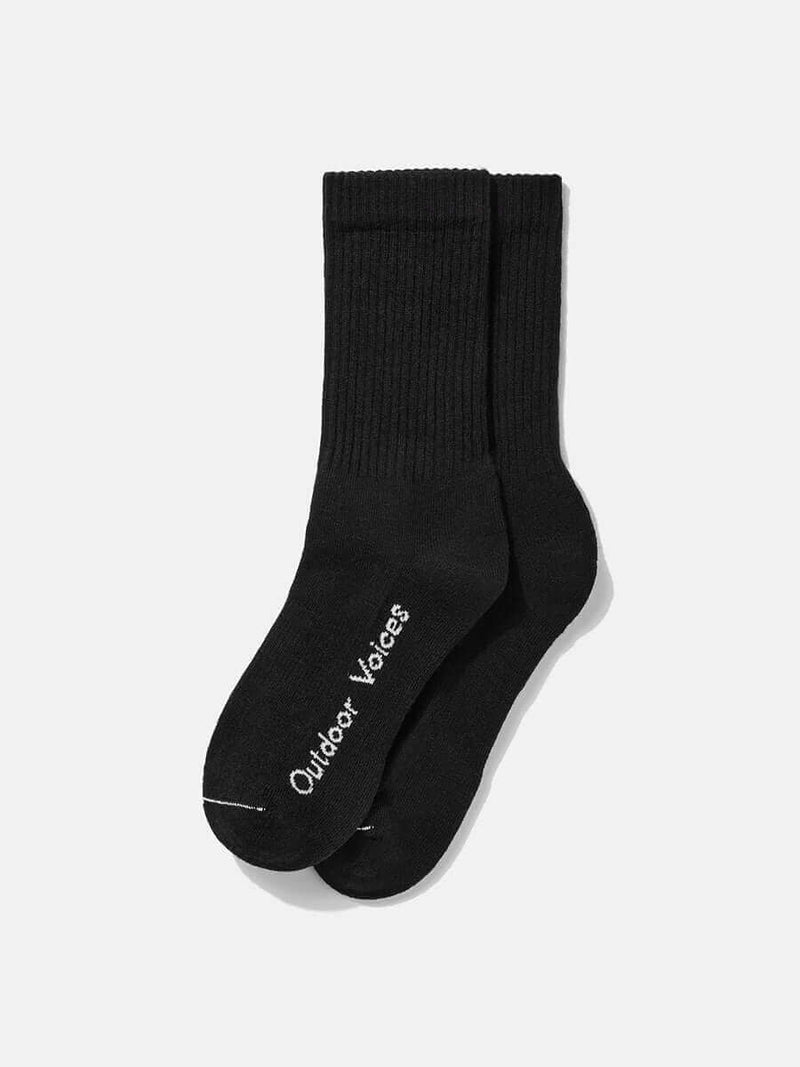 Flat lay of OV Solid Crew Sock in Black, featuring plush RecKnit and Outdoor Voices logo on the foot.