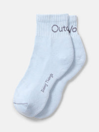 Flat lay of OV Rec Ankle Sock in light blue featuring a soft knit material and ribbed cuff.