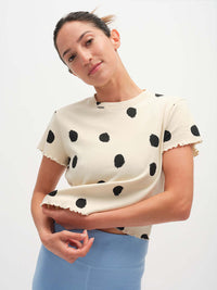 Model wearing Polka Tee in cream with polka dot print and lettuce edge finish, styled for everyday wear.