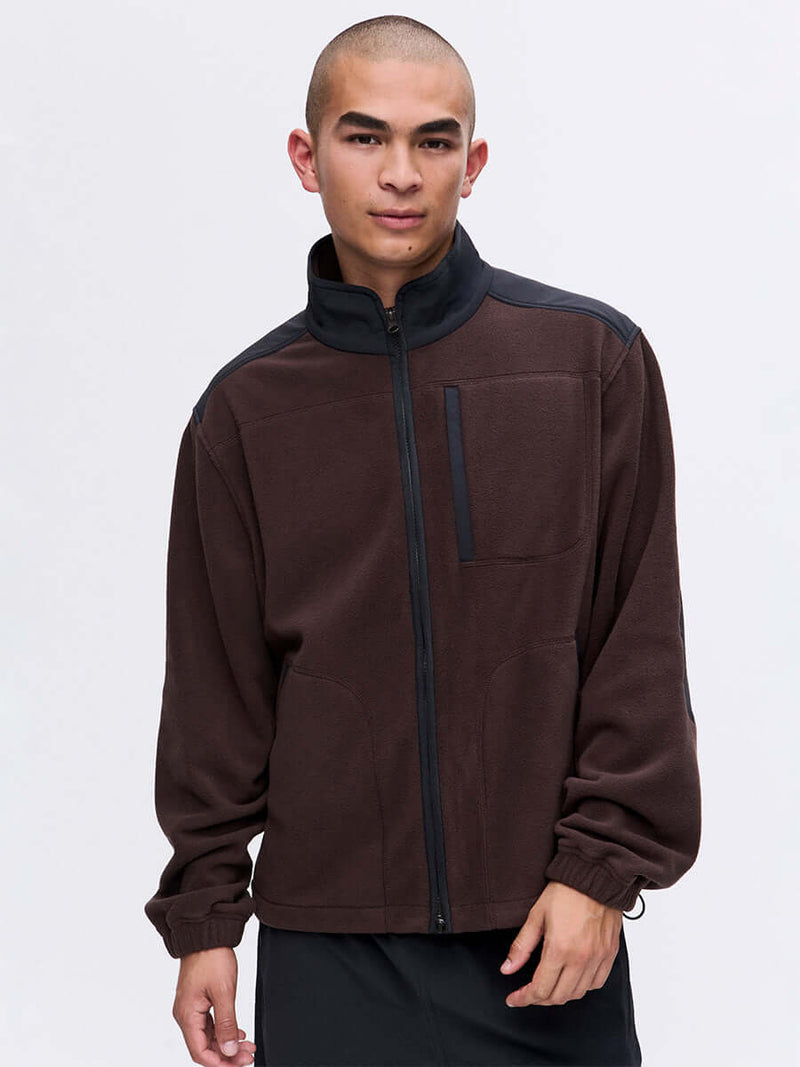 Model wearing RecFleece Relaxed Full Zip in Brown, featuring contrast shoulder panels and chest pocket.
