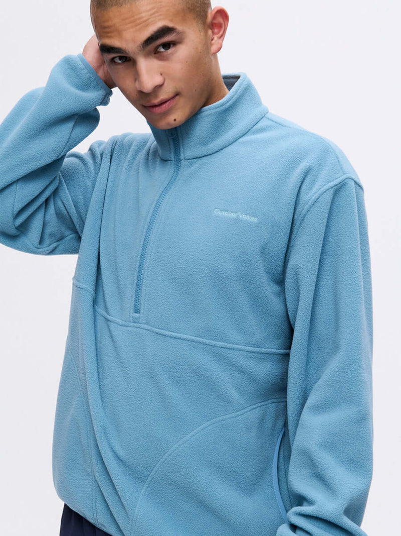 Model posing in RecFleece 1/2 Zip in Light Blue, featuring a front ½ zip and relaxed fit.