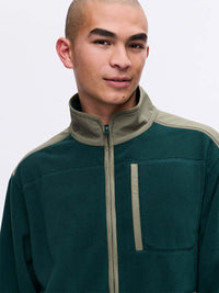 Model wearing RecFleece Relaxed Full Zip in Dark Green, featuring contrast shoulder panels and chest pocket.