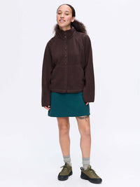 Model wearing RecFleece Snap Jacket in Dark Brown, featuring a snap front and dolman sleeves for a roomy fit.