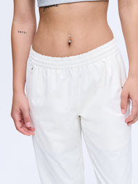 Model in cropped top wearing RecTrek 26" Pant in White, featuring an adjustable waistband and two front pockets.