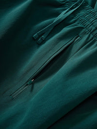 Close-up detail of RecTrek 26" Pant in Deep Teal showing elastic waistband and zippered pocket for secure storage.