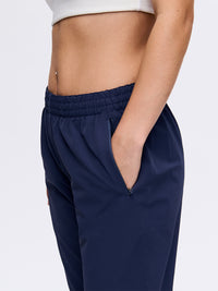Side view of model wearing RecTrek 29" Pant in Navy with elastic waistband and pockets, ideal for everyday wear.