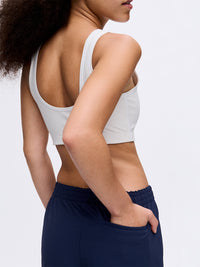 Model from the back wearing a white sports bra and navy RecTrek 29" Pant, with side pocket detail.