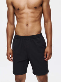 Model wearing RecTrek 7" Short in Black, featuring an adjustable drawstring and zippered pockets.