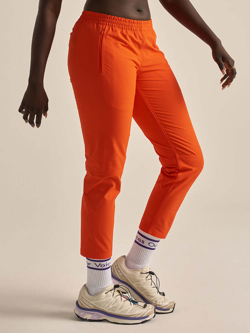 Model wearing RecTrek 26" Pant in Orange, with the comfy elastic waistband and sleek design.