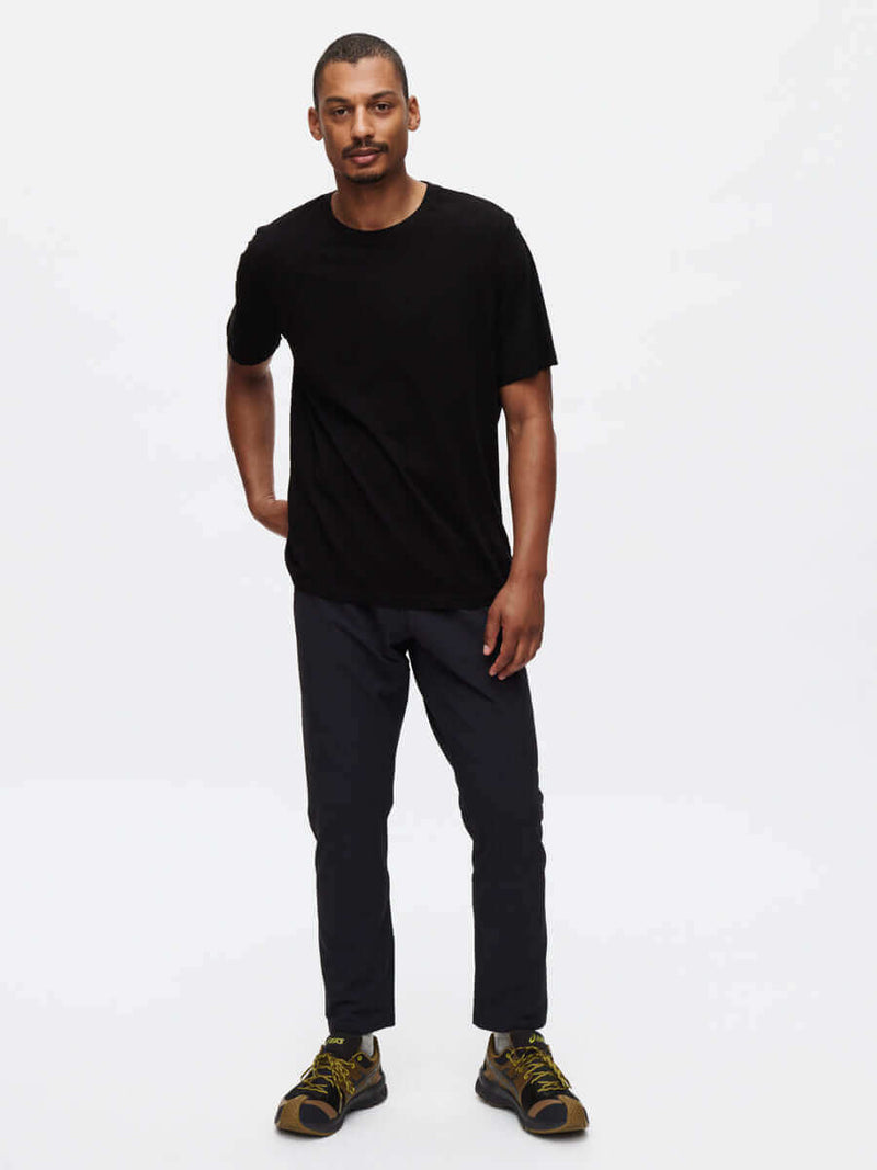 Model standing in relaxed fit RecTrek Pant in Black, featuring adjustable drawstring and zippered pockets.