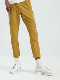 Model in relaxed fit RecTrek Pant in Gold, featuring a pull-on design and stretchy material for easy movement.