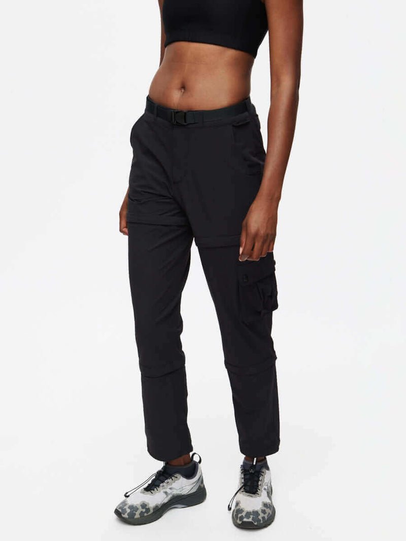 Model wearing RecTrek Zip-Off Pant in Black, featuring zip-off sections and a sleek, adjustable waistband.