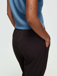 Back view of model wearing RecTrek Zip Pant in Black, showing the back pocket detail.