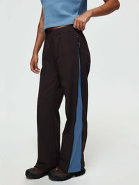Model standing in profile wearing RecTrek Zip Pant in Black with side zipper panels for added ventilation.