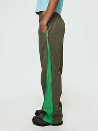 Side view of model wearing RecTrek Zip Pant in Olive Green with mesh panels for ventilation.