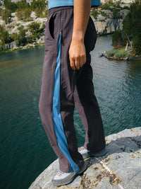 Side view of model wearing RecTrek Zip Pant in Dark Grey with zipper vents revealing mesh panels, ideal for hiking.