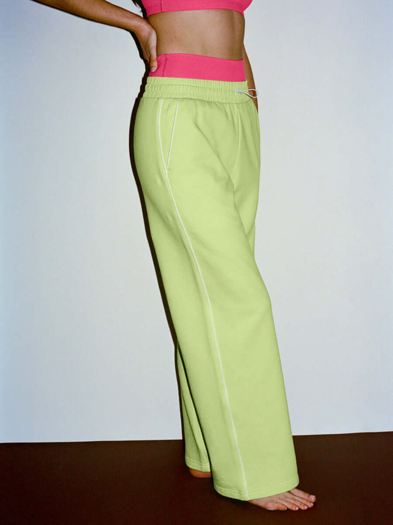 Model in a side view wearing Sport Sweatpant in Lime with wide leg design and a technical nylon waistband.