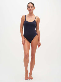 Model standing in Strappy Bodysuit in Navy, featuring adjustable spaghetti straps and a feminine neckline.